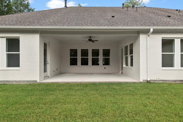 rear view of house with ceiling fan, a yard, and a patio