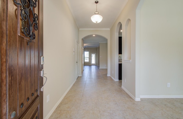 entrance foyer featuring light tile patterned floors and crown molding