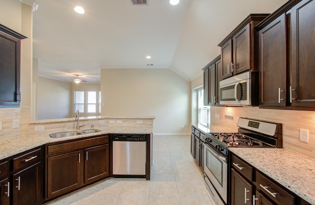 kitchen with appliances with stainless steel finishes, backsplash, ceiling fan, sink, and lofted ceiling