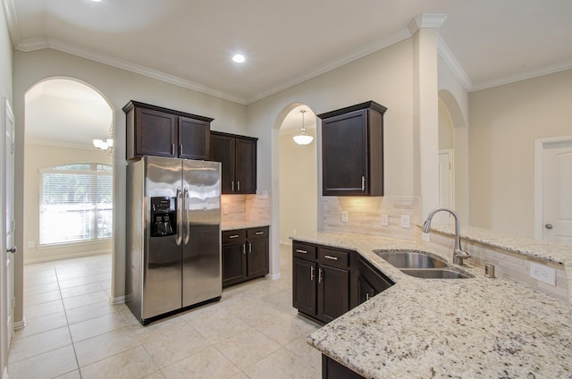 kitchen featuring sink, hanging light fixtures, backsplash, stainless steel fridge, and crown molding