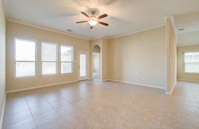 tiled empty room featuring ceiling fan, crown molding, and a wealth of natural light