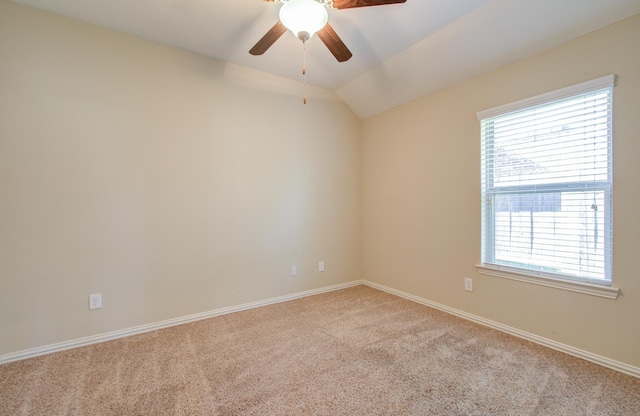 spare room featuring light carpet, vaulted ceiling, plenty of natural light, and ceiling fan