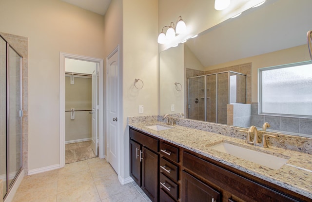 bathroom featuring tile patterned flooring, vanity, a shower with door, and lofted ceiling