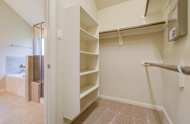 walk in closet featuring light tile patterned floors and vaulted ceiling