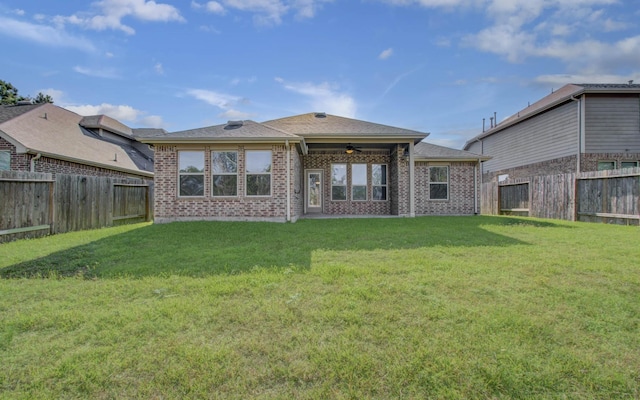 rear view of property with a yard and ceiling fan