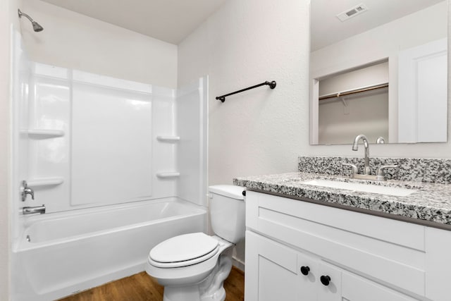 full bathroom with vanity, hardwood / wood-style flooring, toilet, and shower / washtub combination