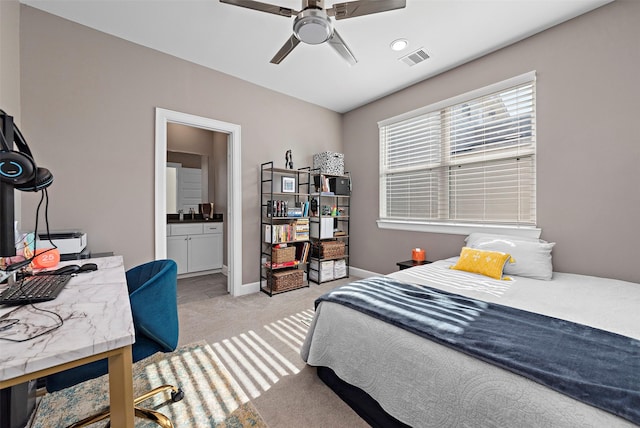 bedroom featuring ensuite bath, ceiling fan, and light carpet