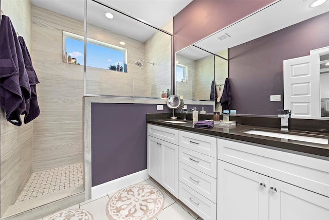 bathroom featuring tile patterned floors, vanity, and a tile shower