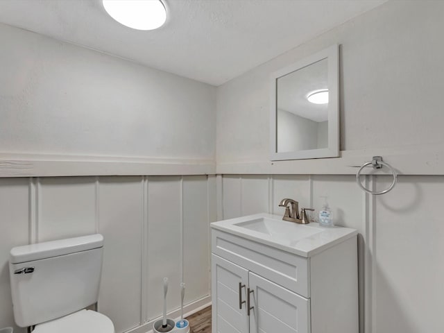24 N Omega St, La Marque, TX 77568 - bathroom featuring wood-type flooring, vanity, and toilet