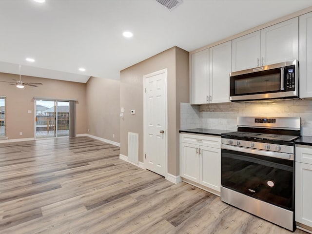24 N Omega St, La Marque, TX 77568 - kitchen with white cabinets, decorative backsplash, light hardwood / wood-style floors, and stainless steel appliances