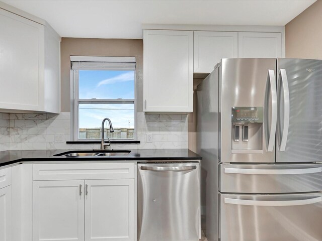 24 N Omega St, La Marque, TX 77568 - kitchen with white cabinets, sink, appliances with stainless steel finishes, and tasteful backsplash