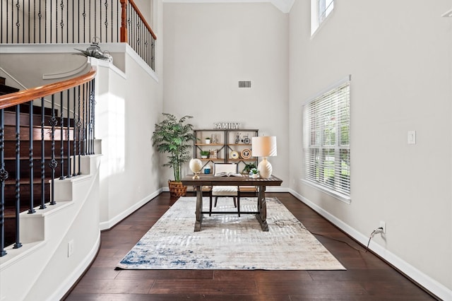 office area featuring dark wood-type flooring and a high ceiling