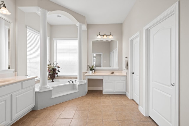 bathroom with tile patterned flooring, a bath, and vanity