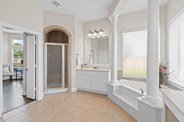 bathroom with tile patterned flooring, vanity, independent shower and bath, and decorative columns