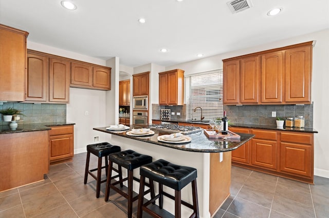 kitchen featuring decorative backsplash, a center island, a breakfast bar area, and appliances with stainless steel finishes