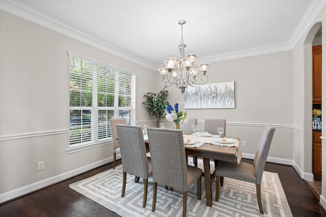 dining area with dark hardwood / wood-style flooring, ornamental molding, and a notable chandelier