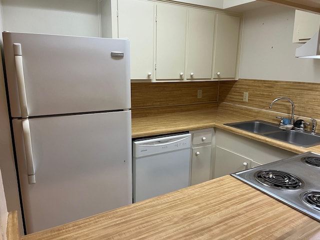 kitchen featuring dishwasher, sink, tasteful backsplash, fridge, and white cabinets