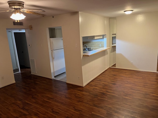 kitchen with white refrigerator, ceiling fan, dark wood-type flooring, and sink