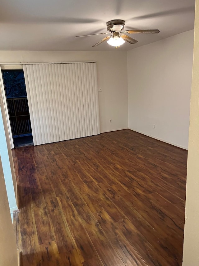 spare room featuring ceiling fan and dark wood-type flooring