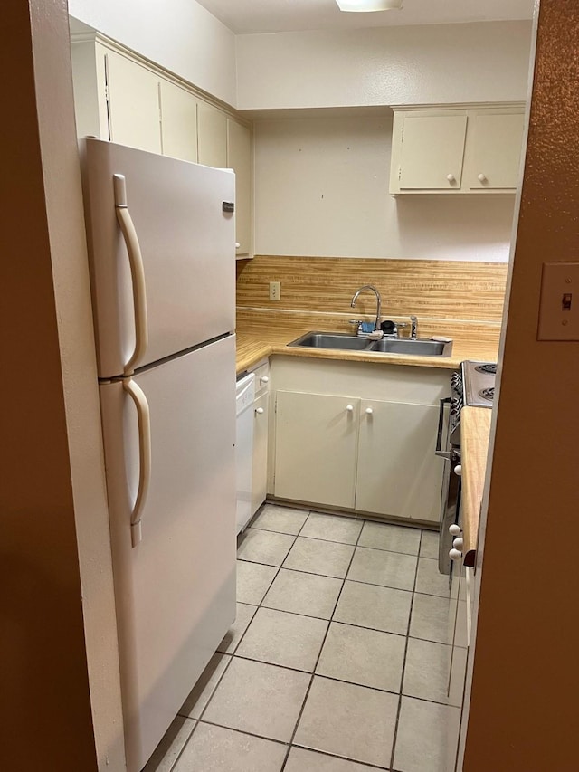 kitchen featuring tasteful backsplash, white appliances, sink, and cream cabinets