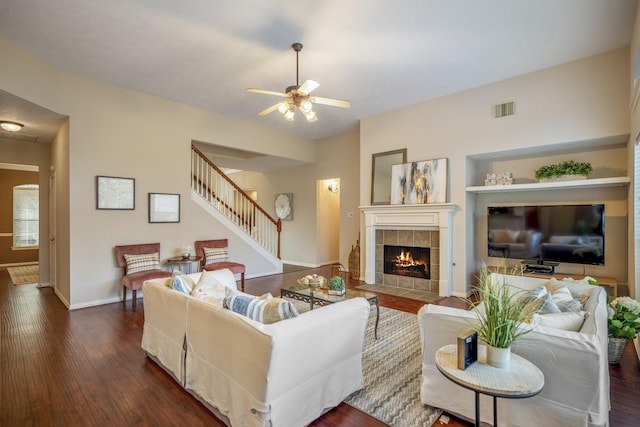 living room with a fireplace, dark hardwood / wood-style flooring, and ceiling fan