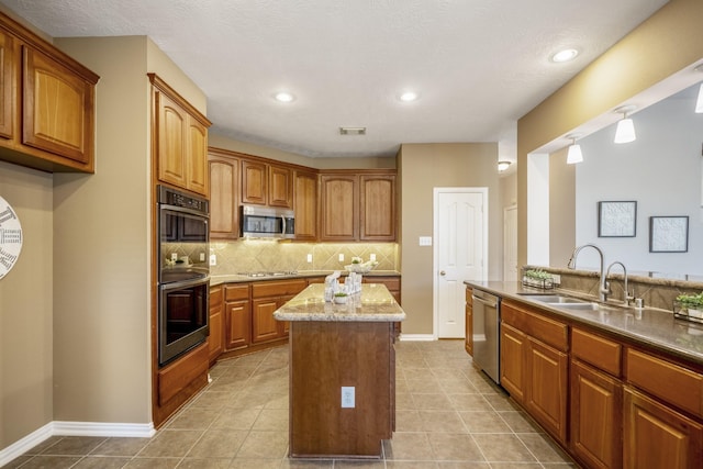 kitchen featuring a center island, sink, stainless steel appliances, decorative backsplash, and light tile patterned floors