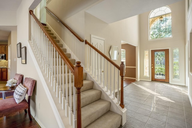 entrance foyer featuring a towering ceiling and light hardwood / wood-style flooring