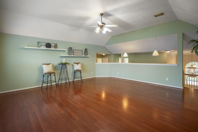 interior space with vaulted ceiling, ceiling fan, a textured ceiling, and dark hardwood / wood-style floors