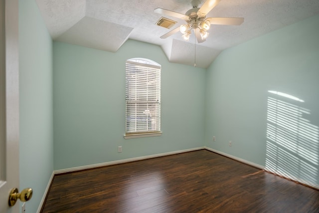 empty room with a textured ceiling, ceiling fan, dark wood-type flooring, and lofted ceiling