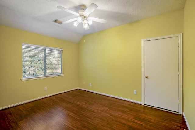 empty room with ceiling fan, dark hardwood / wood-style flooring, lofted ceiling, and a textured ceiling