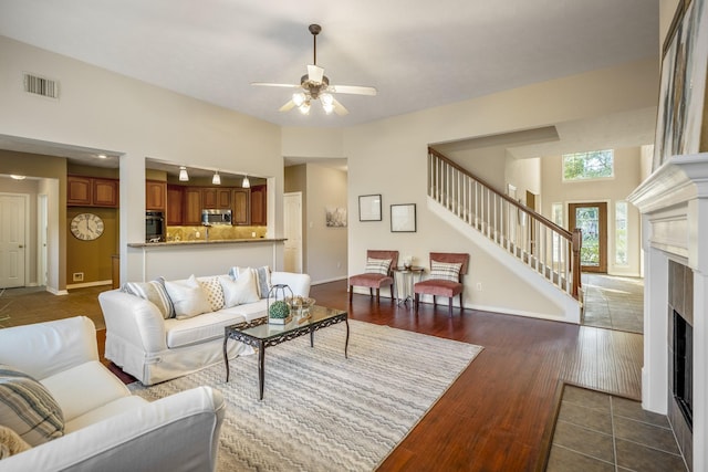 living room with ceiling fan and dark hardwood / wood-style flooring