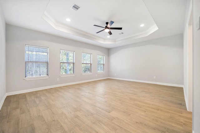 unfurnished room featuring a tray ceiling, light hardwood / wood-style flooring, ceiling fan, and ornamental molding