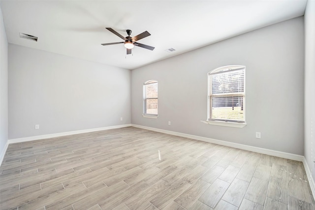 spare room with ceiling fan, plenty of natural light, and light hardwood / wood-style flooring