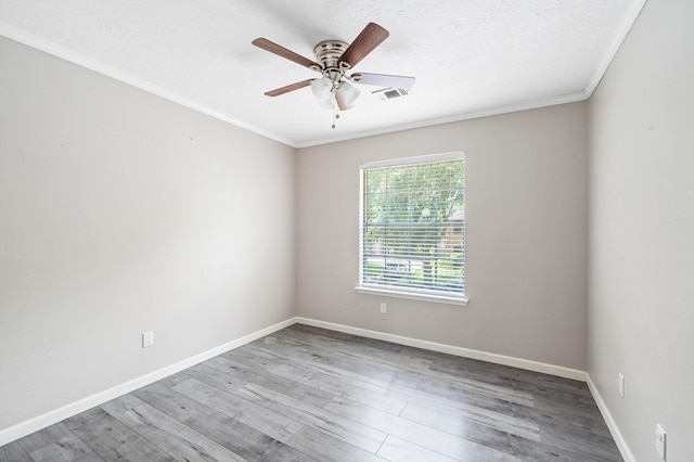 spare room featuring hardwood / wood-style floors, a textured ceiling, ceiling fan, and ornamental molding