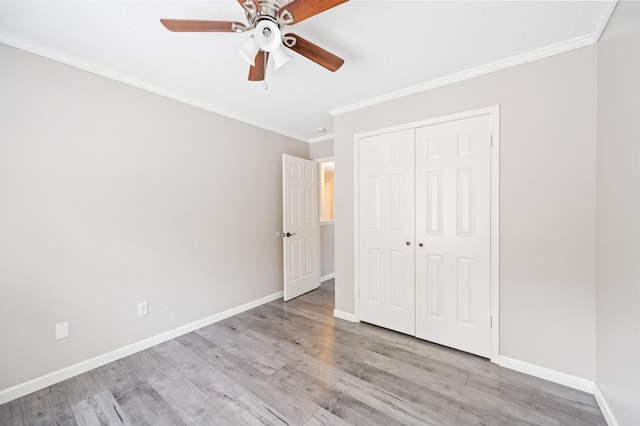 unfurnished bedroom with ceiling fan, light hardwood / wood-style floors, ornamental molding, and a closet