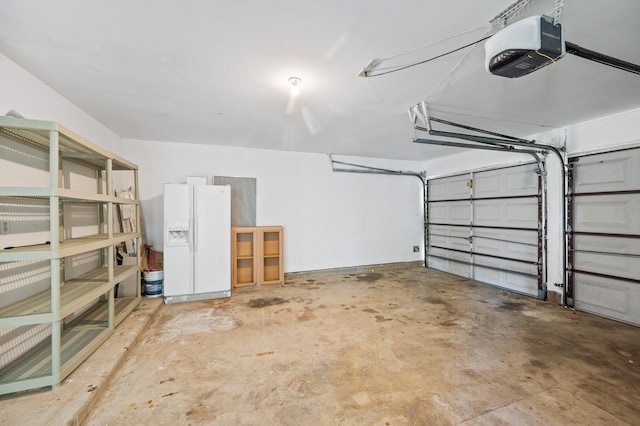 garage featuring white fridge with ice dispenser and a garage door opener