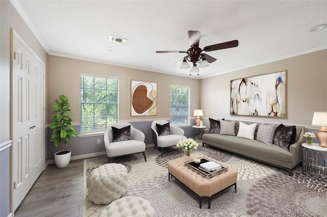 living room featuring a textured ceiling, ceiling fan, wood-type flooring, and ornamental molding