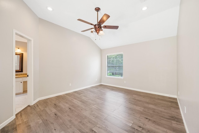 spare room featuring ceiling fan, wood-type flooring, and vaulted ceiling