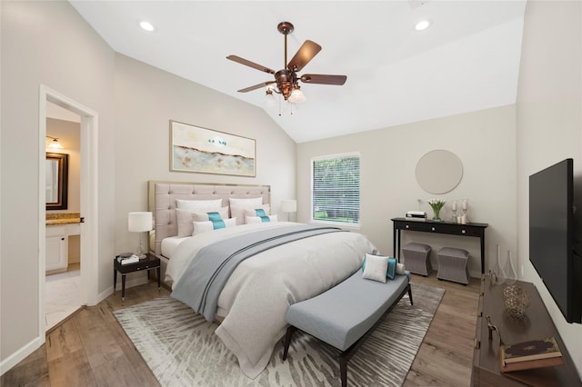 bedroom featuring hardwood / wood-style flooring, ceiling fan, lofted ceiling, and connected bathroom