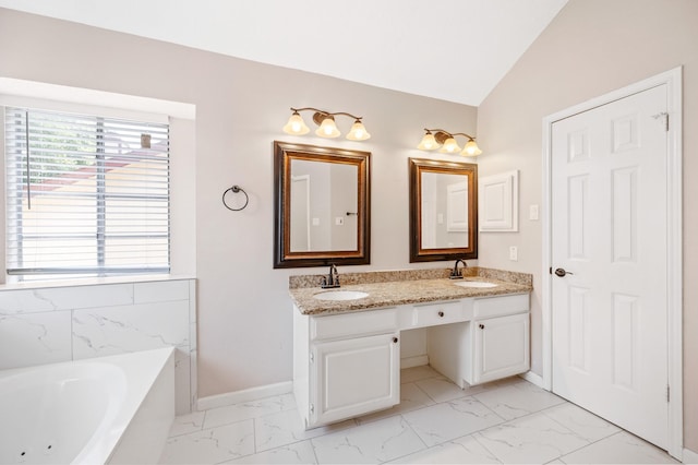 bathroom featuring vanity, a bath, and lofted ceiling