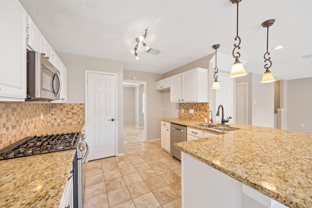 kitchen with backsplash, stainless steel appliances, sink, decorative light fixtures, and white cabinets