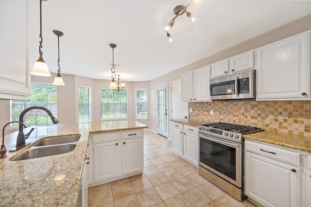 kitchen featuring backsplash, stainless steel appliances, sink, white cabinetry, and hanging light fixtures