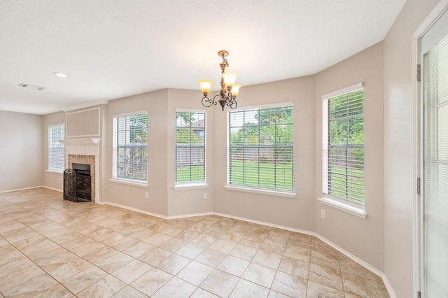 unfurnished dining area with a textured ceiling and a notable chandelier