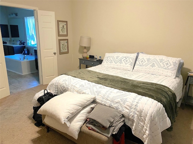 carpeted bedroom featuring ensuite bath and sink