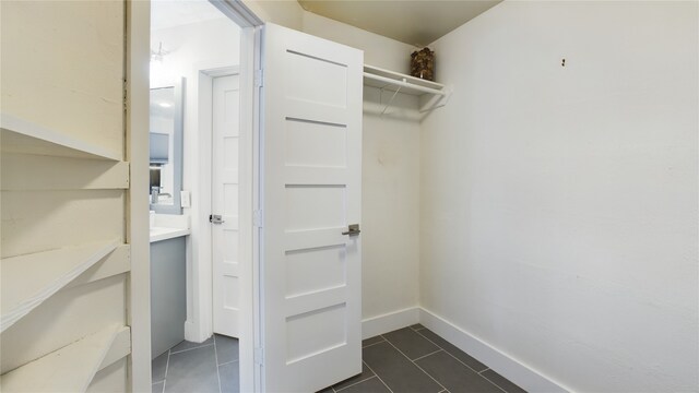 spacious closet featuring dark tile patterned flooring