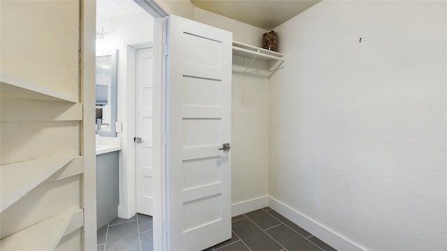 walk in closet featuring dark tile patterned floors