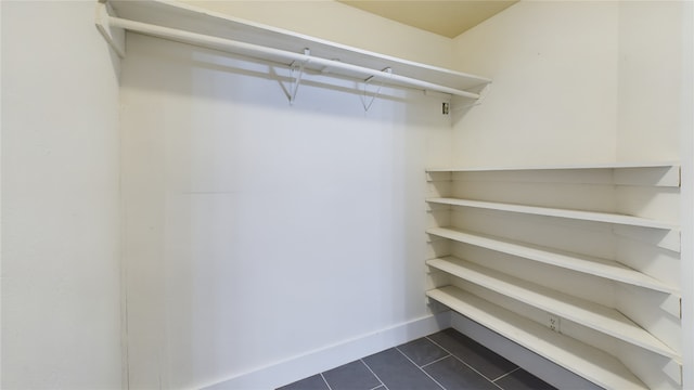 walk in closet featuring dark tile patterned floors