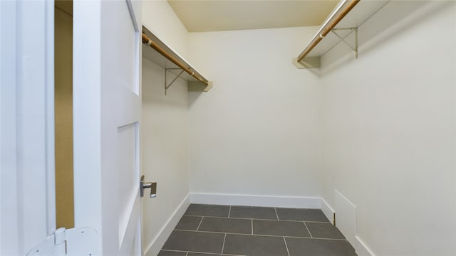 spacious closet featuring dark tile patterned floors