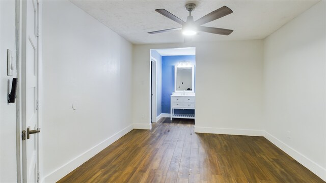 unfurnished bedroom with ceiling fan and dark wood-type flooring