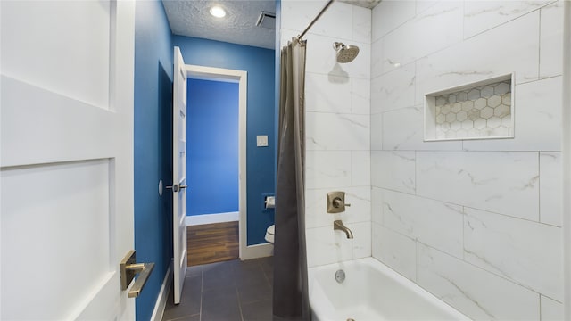 bathroom with shower / tub combo with curtain, tile patterned flooring, a textured ceiling, and toilet